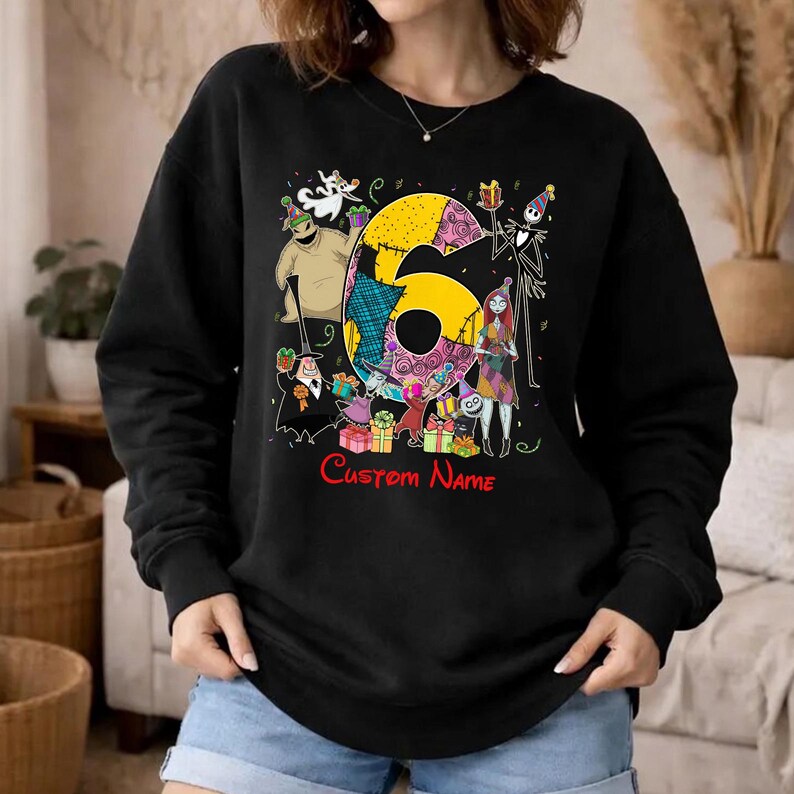 May include: A black long-sleeve sweatshirt featuring a large yellow number six surrounded by various animated characters in party hats and colorful gift boxes. The text Custom Name is printed in red below the graphic design.