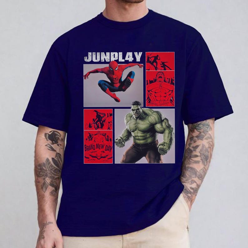 Op de afbeelding: Marineblauwe t-shirt met een grafisch ontwerp met Spider-Man en Hulk, met de tekst "JUNPLAY". Het ontwerp bevat rode en witte accenten, met de woorden "BRAND NEW DAY".