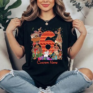 May include: A black t-shirt featuring a large orange patterned number six surrounded by various animated characters wearing party hats. Below the number, the text Custom Name is printed in red, accompanied by colorful gift boxes and confetti.
