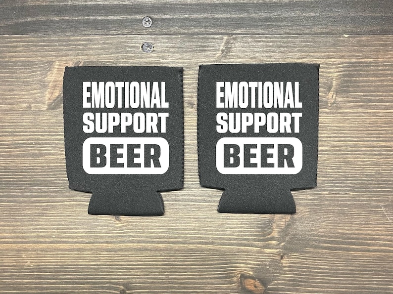 May include: Two black foam beverage insulators with white text that reads "Emotional Support Beer".