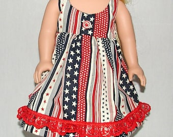 May include: A red, white, and blue striped dress with white stars and a red lace trim. The dress is made for a doll.