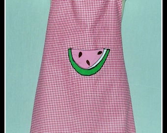 May include: Pink and white gingham apron with a watermelon applique. The apron has ruffled straps.