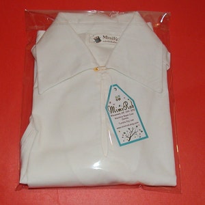 May include: White collared shirt in a clear plastic bag with a tag that reads "Mimi Rob Wiecasses, ME USA 2012 Machine Wash Cold Gentle Tumble Dry Low www.mimirob.etsy.com"