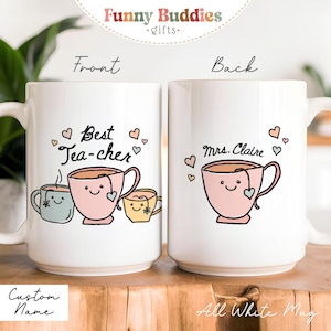 May include: White ceramic mug with a whimsical design for teachers. The front features the text "Best Tea-cher" with smiling teacups and hearts. The back says "Mrs. Claire" with a teacup. The mug has a large handle.