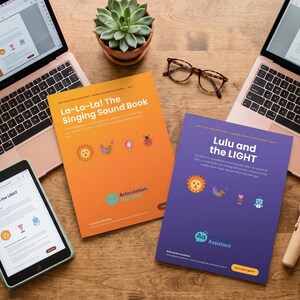 Peut inclure: Deux ordinateurs portables ouverts et une tablette affichent du contenu éducatif à côté de deux livres imprimés intitulés La-La-La! The Singing Sound Book et Lulu and the LIGHT. Une petite plante grasse, des lunettes et deux petits micros jouets.