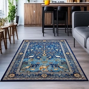 Puede incluir: Una alfombra azul y crema con un diseño de árbol de la vida. La alfombra tiene un borde detallado con intrincados motivos florales.