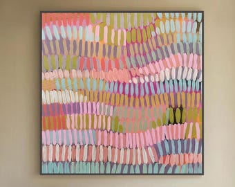Puede incluir: Gran pintura abstracta enmarcada, con pinceladas verticales en tonos rosa, morado, verde y naranja. La obra cuelga sobre un sofá blanco en un salón moderno. Los colores crean un efecto visual vibrante y texturizado, añadiendo un punto focal.