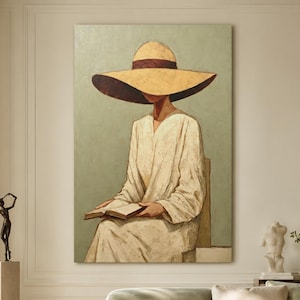 May include: A vertical wall art print featuring a painting of a person wearing a wide-brimmed yellow hat and a long, light-coloured robe, sitting and reading an open book against a muted sage green background with visible brushstroke textures.