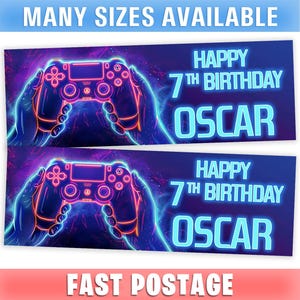 May include: A banner with a neon-style illustration of a video game controller held in hands. The banner reads "HAPPY 7TH BIRTHDAY OSCAR" in bright blue letters against a dark purple background. The text "MANY SIZES AVAILABLE" is at the top.