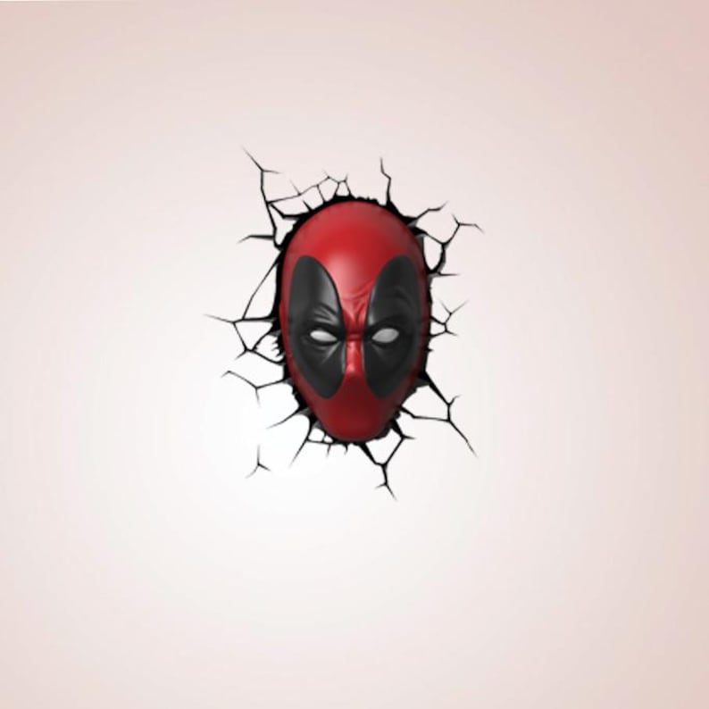 May include: A red and black Deadpool mask breaking through a cracked wall. The mask has black eye coverings and white eye details. The wall is a pale pink colour.