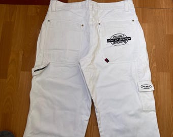 Könnte beinhalten: Weiße Jeanshose mit mehreren Taschen und dem Logo "FUBU Art of Design SPORTS" auf der Gesäßtasche. Die Hose hat eine lockere Passform und eine Cargotasche an der Seite. Hergestellt aus robustem Denim-Material.