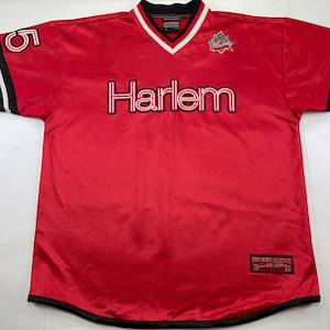 May include: Red jersey with "Harlem" in white and black lettering across the chest. The jersey has a V-neck with white trim, black and white stripes on the sleeves, and the number "5" on the left sleeve. A logo is on the upper right chest.
