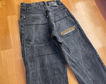 May include: Dark gray denim jeans with a faded wash. Features large back pockets and the "SOUTHPOLE" logo in orange on the right pocket. The jeans have a classic, relaxed fit.