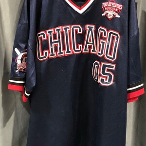 May include: Navy blue baseball jersey with the word "CHICAGO" in white and red lettering across the chest, and the number "05" below. The jersey has a V-neck with red and white trim, and red trim on the sleeves and bottom.