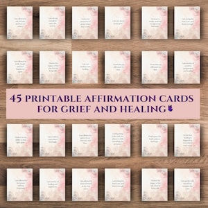 May include: A collection of 45 printable affirmation cards for grief and healing. Each card features a floral design and a positive affirmation in a soft, elegant font. The cards are arranged on a wooden surface.
