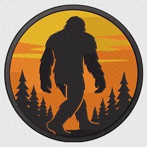 Op de afbeelding: Geborduurde ronde patch met een zwart silhouet van Bigfoot tegen een oranje zonsondergang en dennenbomen. De tekst "5 SIZE" staat bovenaan. De onderste tekst bevat "DTS, PES, XXX, EXP, JEF, SEW, VP3, HUS".