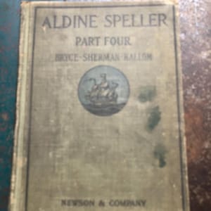 May include: A vintage hardcover book titled Aldine Speller Part Four by Bryce-Sherman-Kallom, published by Newson & Company. The cover is a muted olive green with a central circular illustration of a sailing ship and dark text throughout.
