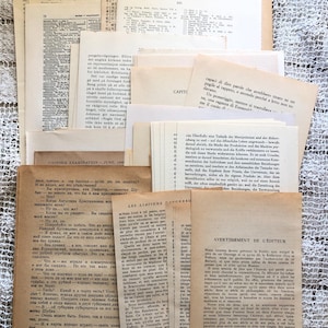 May include: A collection of aged paper ephemera, including pages with text in multiple languages, stacked on a textured, off-white surface. The papers vary in size and font, suggesting a vintage or antique theme.