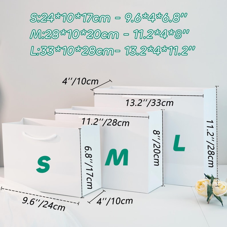 May include: Three white gift bags labeled S, M, and L. The bags have measurements in inches and centimeters. The smallest bag is 9.6" x 4" x 6.8", the medium bag is 11.2" x 4" x 8", and the largest bag is 13.2" x 4" x 11.2".