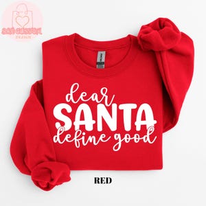 May include: A red sweatshirt with the text "dear SANTA define good" in white script. The sweatshirt has long sleeves and a crew neck. The word "RED" is printed at the bottom.