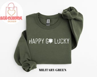 May include: A green sweatshirt with the text "HAPPY GO LUCKY" in white with a four-leaf clover graphic. The sweatshirt is a crew neck style.