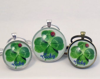 May include: Three silver and bronze keychains with a four-leaf clover design and a ladybug. The keychains have the word "lucky" written on them.