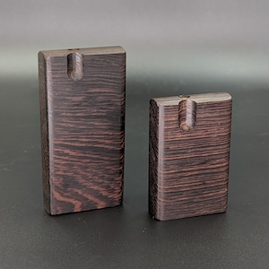 May include: Two wooden boxes with a small hole in the top. The boxes are dark brown with a wood grain pattern.