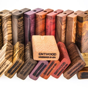 May include: A collection of wooden boxes with different wood grain patterns and colors. The boxes are stacked in a staggered pattern and have the text "ENTWOOD HANDMADE IN USA" printed on them.