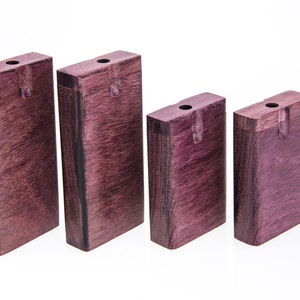 May include: Four wooden boxes with lids, all the same size and shape. The boxes are a deep purple color and have a natural wood grain.
