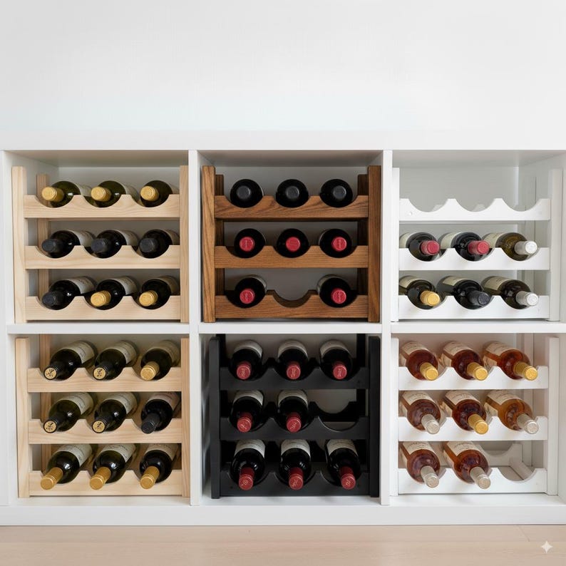 May include: A collection of wine racks in various styles and finishes. The racks are made of wood and painted white, black, and natural wood tones. Each rack holds multiple bottles of wine, showcasing the bottles' labels.