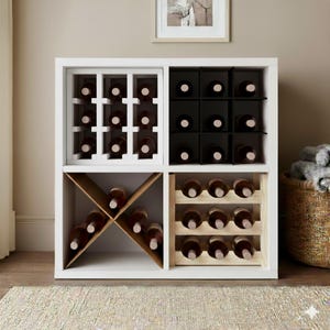 May include: A white wine rack with four compartments, each designed to hold wine bottles. The rack has a modern design, with some sections featuring a grid pattern and others with angled or horizontal storage. The bottles are visible, showcasing their labels.