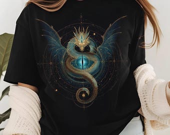 May include: Black t-shirt featuring a detailed illustration of a dragon with blue wings and a golden head. The dragon is centered on a circular design with celestial elements. The design is intricate and fantasy-themed.