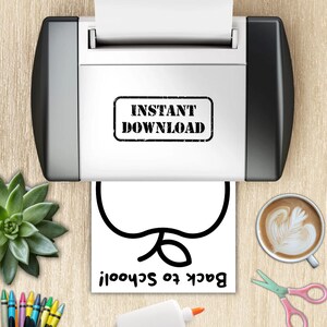 May include: A printer with the text "INSTANT DOWNLOAD" is printing a white paper with a black apple outline and the text "Back to School!". A succulent, coffee, scissors, glue, and crayons are also visible.