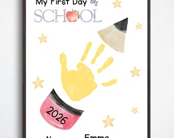 May include: A white poster with the text My First Day of SCHOOL featuring a watercolor apple, a yellow handprint forming a pencil shape, pink eraser with 2026, yellow stars, and the name Emma printed on a line at the bottom of the page.