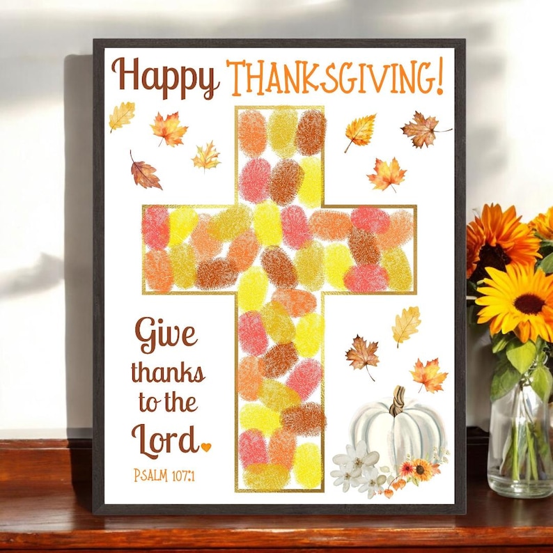 Puede incluir: Impresi&oacute;n art&iacute;stica enmarcada con tem&aacute;tica de Acci&oacute;n de Gracias. La obra presenta una cruz llena de huellas dactilares coloridas. Se muestran las palabras "Happy Thanksgiving!" y "Give thanks to the Lord". Tambi&eacute;n se incluye una calabaza blanca y hojas de oto&ntilde;o.
