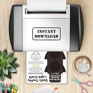 May include: A printer is shown with a printed sheet featuring a black traffic light craft design. The sheet includes the text "God's Traffic Light Craft" and instructions. A cup of coffee, scissors, and glue are also visible.