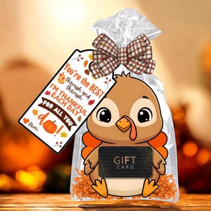 May include: Thanksgiving gift bag featuring a cartoon turkey holding a gift card. The bag is clear with a brown plaid bow and a tag that reads "You're the BEST through and through, I'M THANKFUL EACH DAY FOR ALL YOU do!"