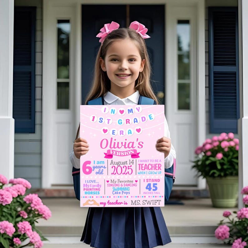 May include: A pink sign held by a young girl, with text saying "In My 1st Grade Era, Olivia's Version." The sign includes details like the girl's age, the date, her height (114 cm), and her teacher's name.