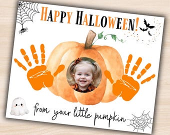 May include: A Halloween card with a pumpkin design. The card features the text "HAPPY HALLOWEEN!" in orange and black, with a child's photo in the centre. Orange handprints frame the pumpkin, and the text "from your little pumpkin" is written below.