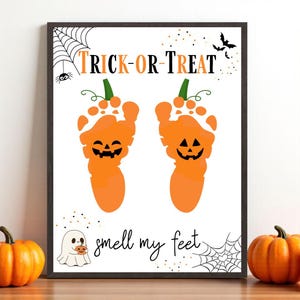 Puede incluir: Un cartel enmarcado con temática de Halloween con huellas de pies naranjas con forma de calabazas con caras de jack-o'-lantern. Las palabras "TRICK-OR-TREAT" y "smell my feet" están escritas. Incluye un fantasma, murciélagos y telarañas.