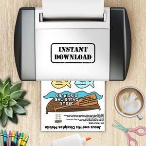 May include: A printer is shown with a printed sheet that reads "Instant Download". The sheet features a boat with the text "Jesus Calls the Disciples" and instructions for a mobile craft. Additional elements include fish illustrations and the names of the disciples.