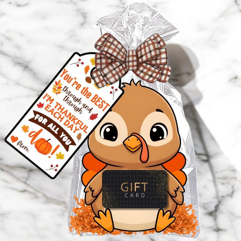 May include: A Thanksgiving-themed gift bag with a cartoon turkey holding a gift card. The bag is clear with a brown plaid bow and a tag that reads "You're the BEST...I'M THANKFUL EACH DAY FOR ALL YOU do!"
