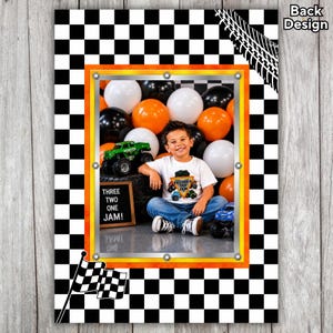 May include: A framed photograph of a young boy wearing a monster truck t-shirt, with orange, black, and white balloons in the background. The frame has an orange and yellow border, set against a black and white chequered background. A chequered flag is in the lower left corner.