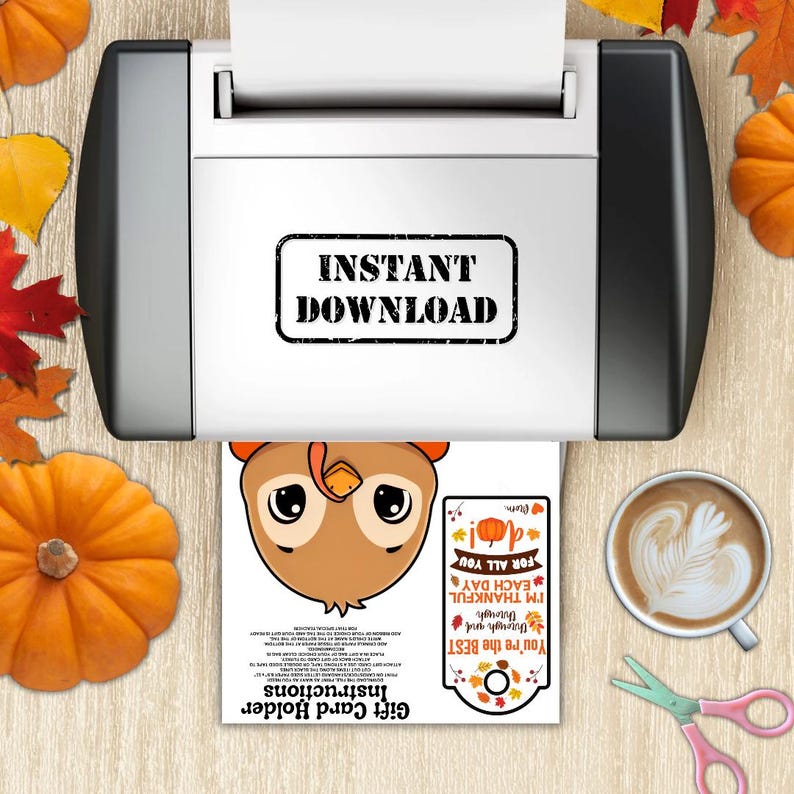 May include: A printer is shown with a printed gift card holder featuring a cartoon owl and the text "Instant Download". The gift card holder has the text "You're the BEST" and "I'M THANKFUL EACH DAY". Pumpkins and fall leaves are scattered around.