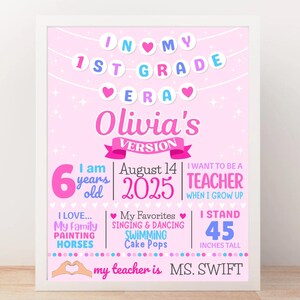 May include: A framed pink 1st Grade Era poster with the name "Olivia's Version". The poster includes text about the child's age, height (114 cm), favorite activities, and future aspirations. The poster is decorated with hearts and stars.