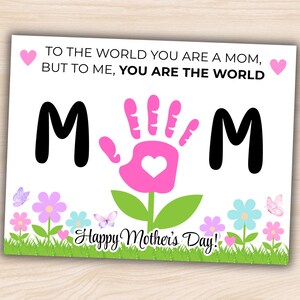 May include: A Mother's Day card with the words "TO THE WORLD YOU ARE A MOM, BUT TO ME, YOU ARE THE WORLD." The word "MOM" is spelled out with the letters "M" and a pink handprint. The card has a floral and butterfly design.