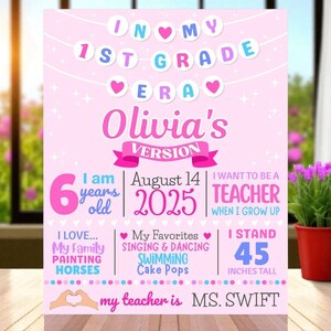 May include: A pink 1st Grade sign with the text "In My 1st Grade Era" and "Olivia's Version." It includes details like age, date, height (114 cm), favorite things, and aspirations. The sign is decorated with hearts and stars.