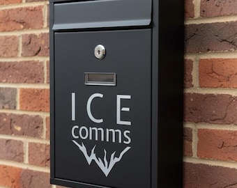 May include: A black mailbox mounted on a brick wall. The mailbox has a slot for mail, a lock, and the text "ICE comms" in white. A decorative graphic is below the text.