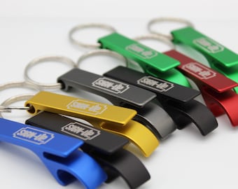 May include: A collection of colorful bottle opener keychains in various colors, including blue, gold, black, gray, green, and red. Each opener has a silver keyring and the text "SIGN-UP" in a white rectangular box.