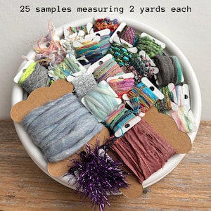 May include: A collection of 25 samples of assorted decorative ribbons and yarns, each measuring 2 yards, wrapped around individual cardboard spools. The assortment includes various textures, metallic finishes, and colors like blue, purple, and green.